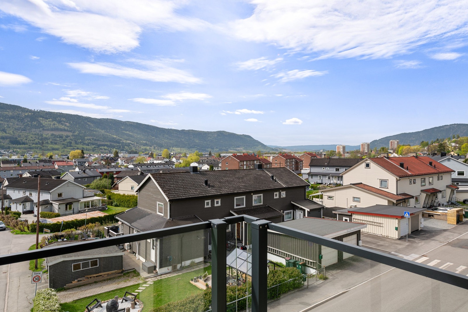 Balkongen har utsikt over nabolaget og åsene i bakgrunnen. Galleribilde