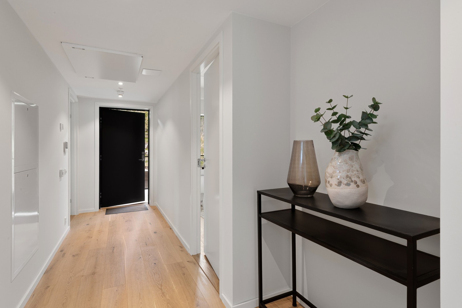 Lys gang med hvite vegger og lyst parkettgulv. Galleribilde