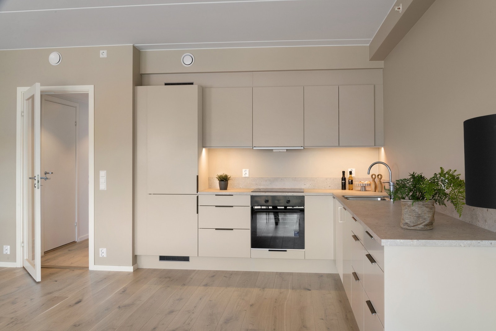 Det er glatt kjøkkeninnredning fra Norema med integrerte hvitevarer som stekeovn, komfyrtopp, kjøleskap og oppvaskemaskin fra Electrolux. Galleribilde