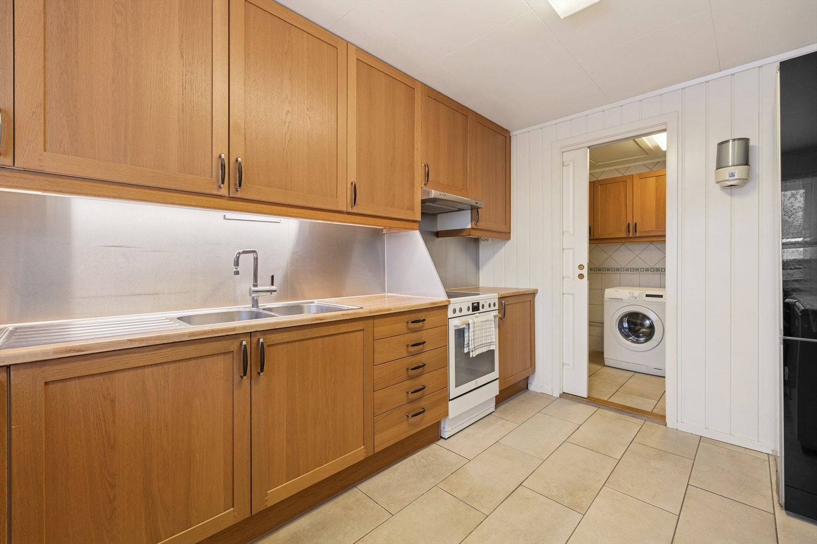 Kjøkkeninnredningen fra 2007 har glatte fronter og en benkeplate av laminat. Galleribilde