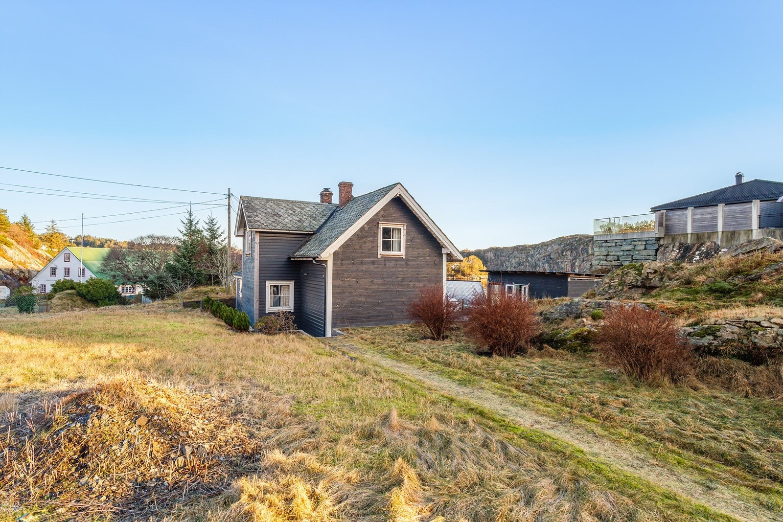 Tomten er opparbeidet med grøntarealer, gruslagt plass, div. prydbusker/beplantning og terrassedekke. Galleribilde