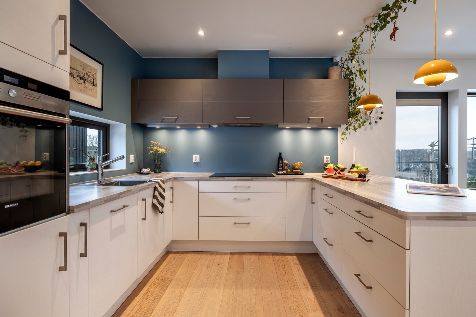 Stilrent kjøkken fra Mobalpa med lyse, slette fronter og laminerte benkeplater med nedfelt oppvaskkum. Galleribilde