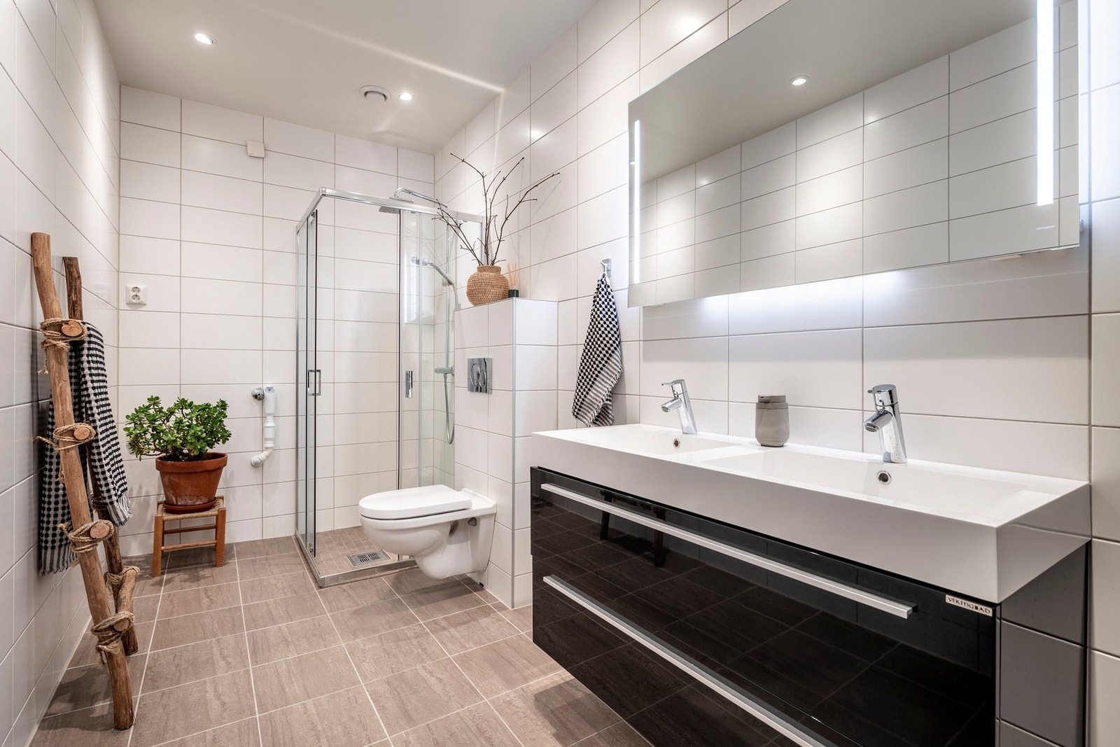 Badet har flislagte vegger- og gulv, varmekabler, innfelt downlights og opplegg for vaskemaskin. Galleribilde