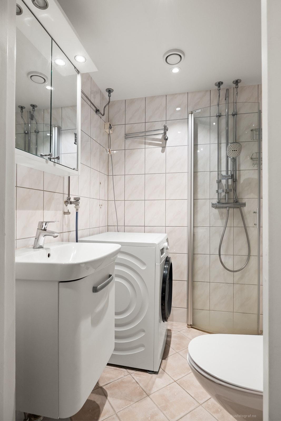 Pent bad som ble totalrenovert i ca. 2010 med fliser på vegger og gulv, varmekabler i gulv, veggmontert toalett, baderomsinnredning med servant, dusjhjørne med foldbare glassdører og opplegg til vaskemaskin. Galleribilde