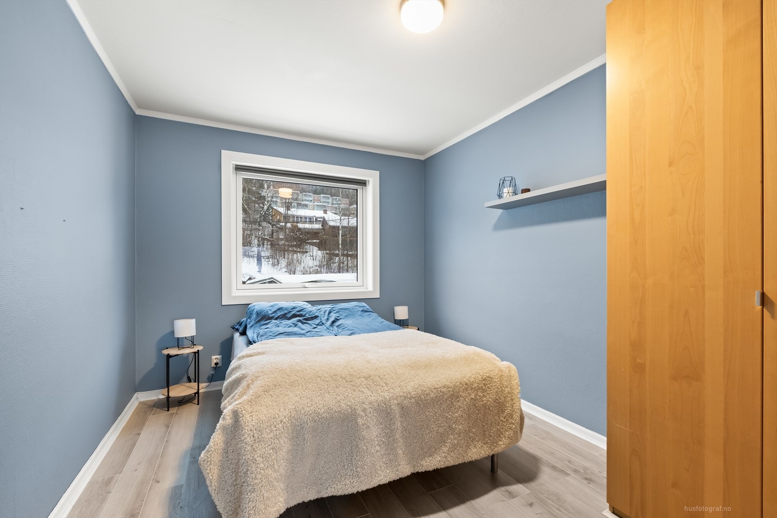 Hyggelig og romslig soverom malt i en behagelig blåtone. Galleribilde