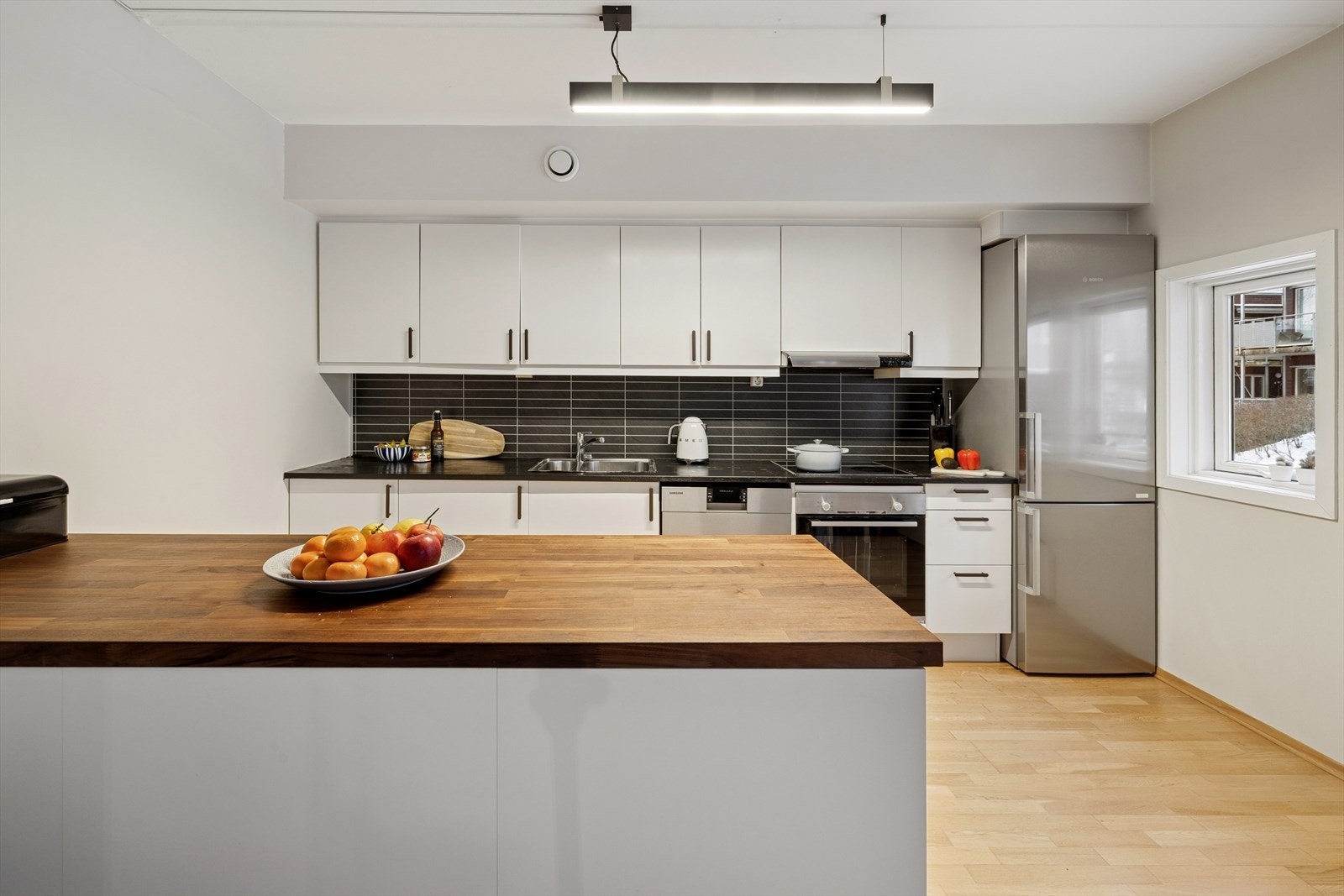 Kjøkkenet har innredning med glatte fronter, integrert platetopp og stekeovn, samt opplegg for oppvaskmaskin og gode oppbevaringsløsninger. Galleribilde