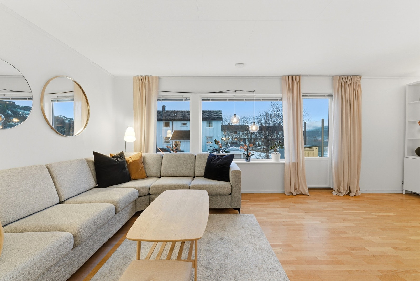 Lys og pen stue med store vindusflater som slipper inn godt med naturlig lys i rommet Galleribilde