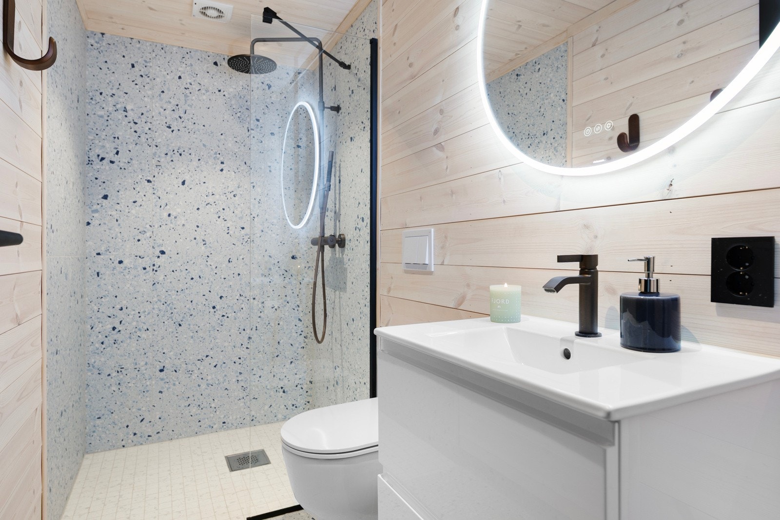 Bad ved entre med flislagt gulv med gulvvarme og panel og fliser på vegger. Galleribilde