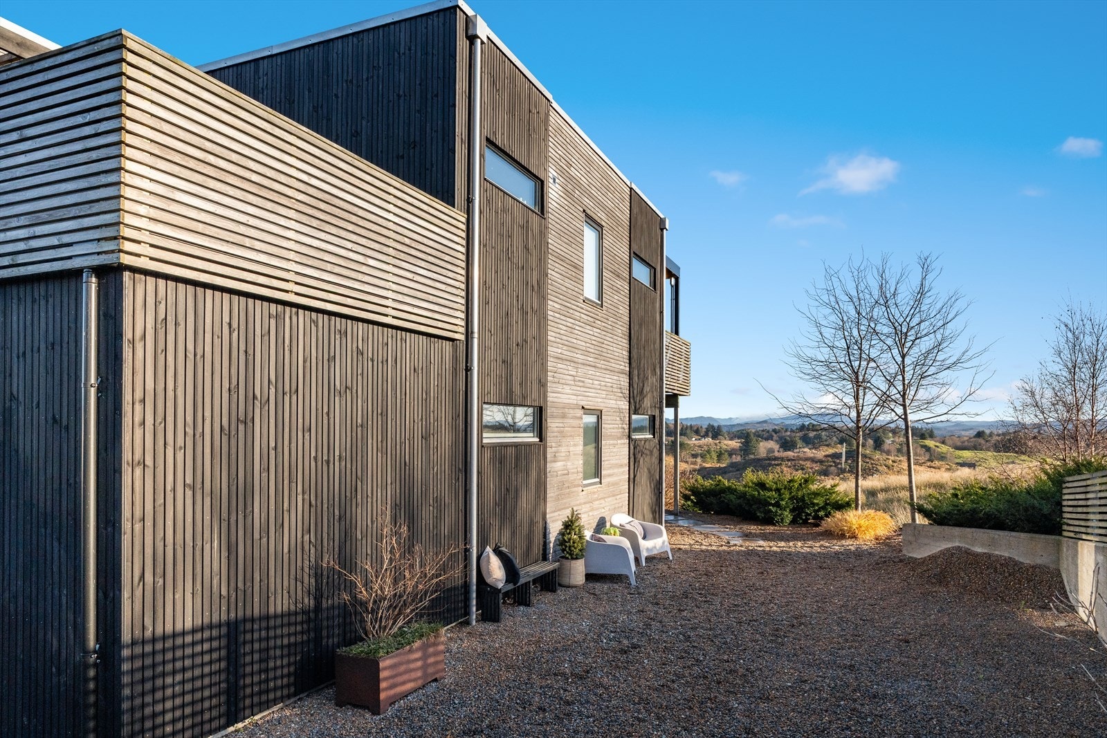 Romslig gårdsplass med god plass til flere biler samt parkering i garasje (med elbillader). Galleribilde