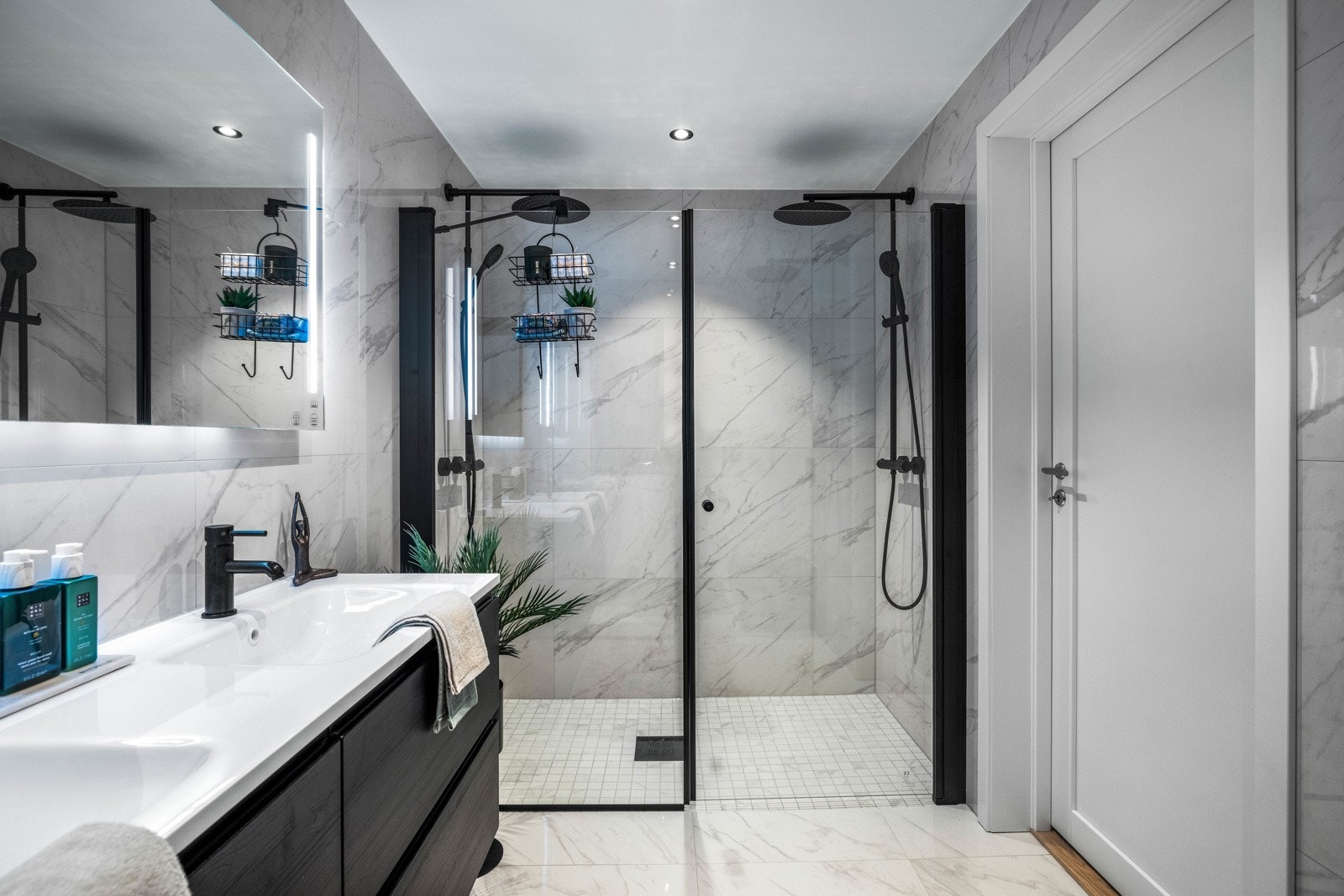 Badet har store marmorerte fliser, gulvvarme og downlights i himlingen. Galleribilde