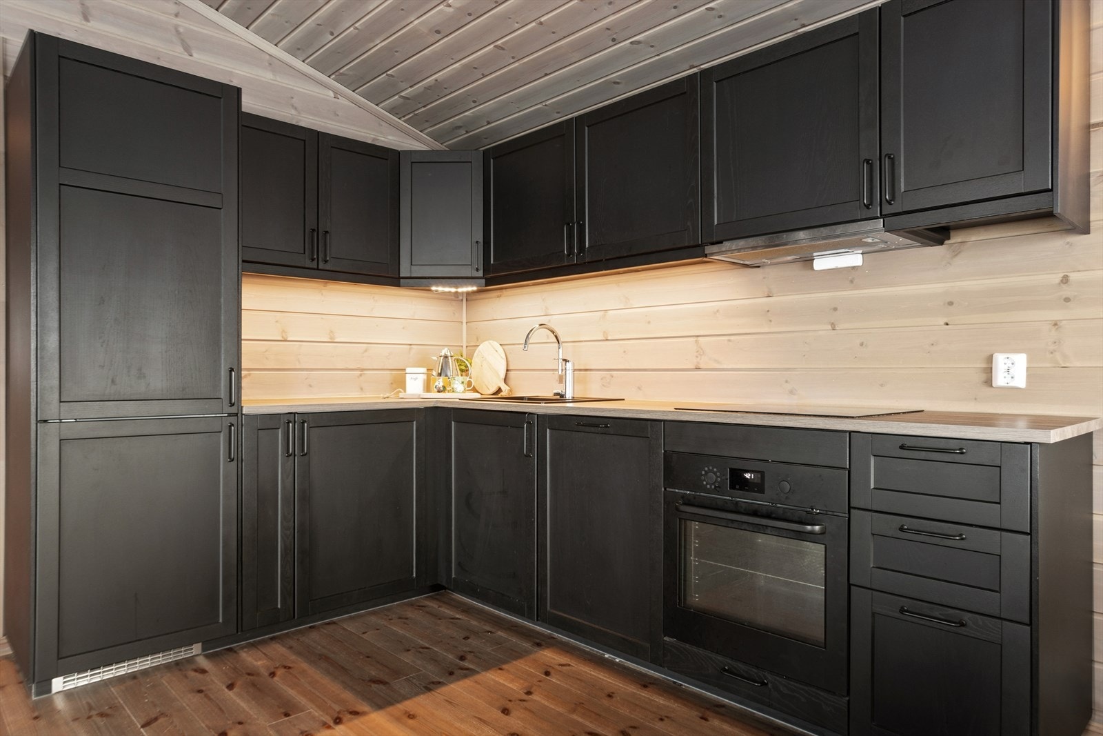 Kjøkkenet ligger i åpen og sosial løsning mot spisesonen, noe som skaper en naturlig flyt mellom matlaging og måltider. Galleribilde