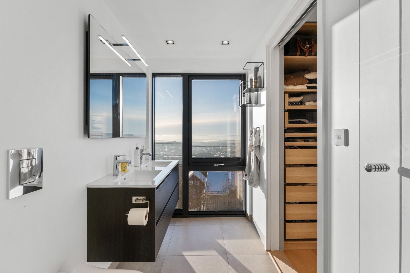 Delikat flislagt bad med vannbåren gulvvarme og store vindusflater som gir rikelig med naturlig lys. Galleribilde