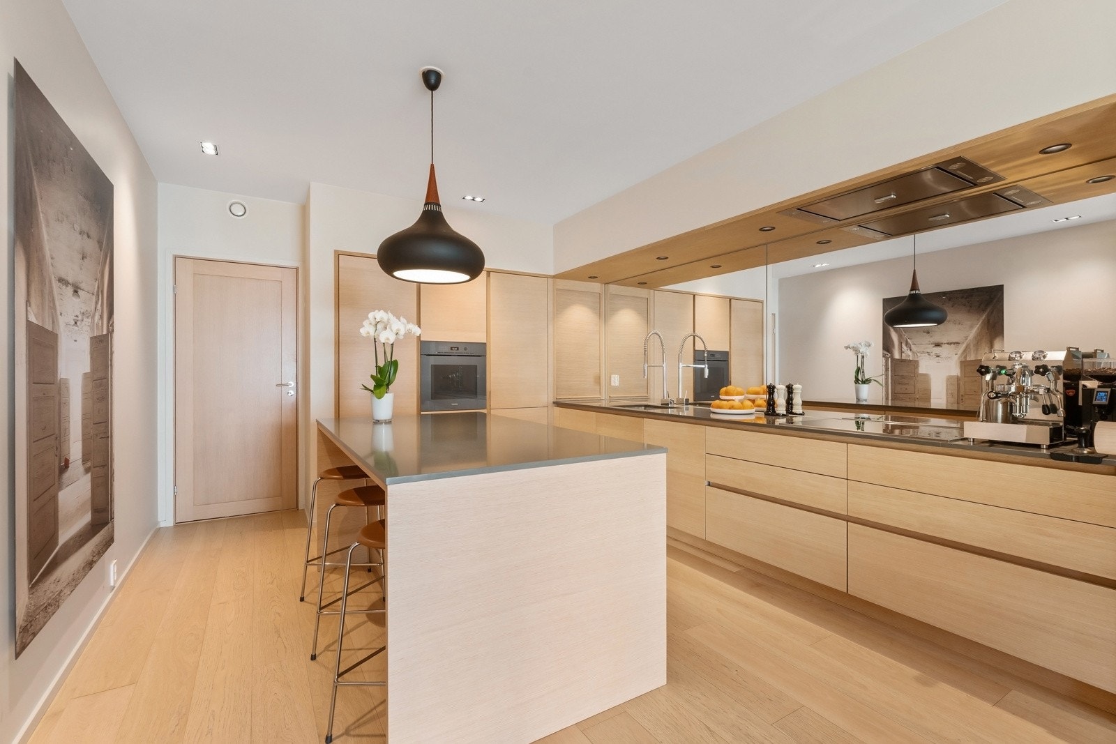 Kjøkkeninnredningen har finerte eikefronter. Det er rikelig med benkeplass samt gode oppbevaringsmuligheter i underskap og integrerte skapløsninger. Galleribilde