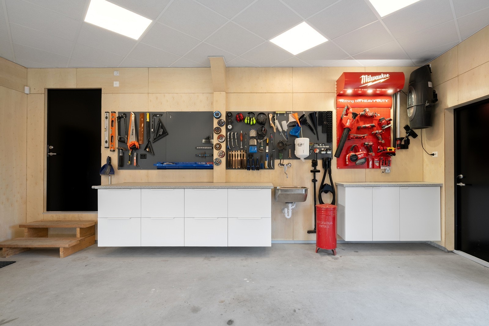 Sluse fra garasje/verksted til bi-inngang. Det er utslagsvask med varmt og kaldt vann. Galleribilde