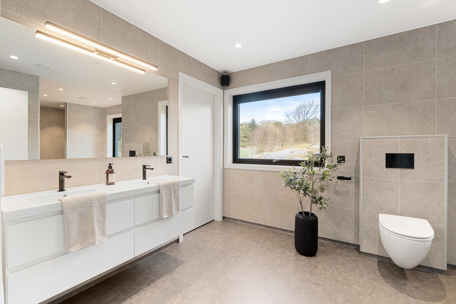 Hovedbad med god størrelse - dobbel servant, vegghengt toalett, dusj og badekar. Galleribilde