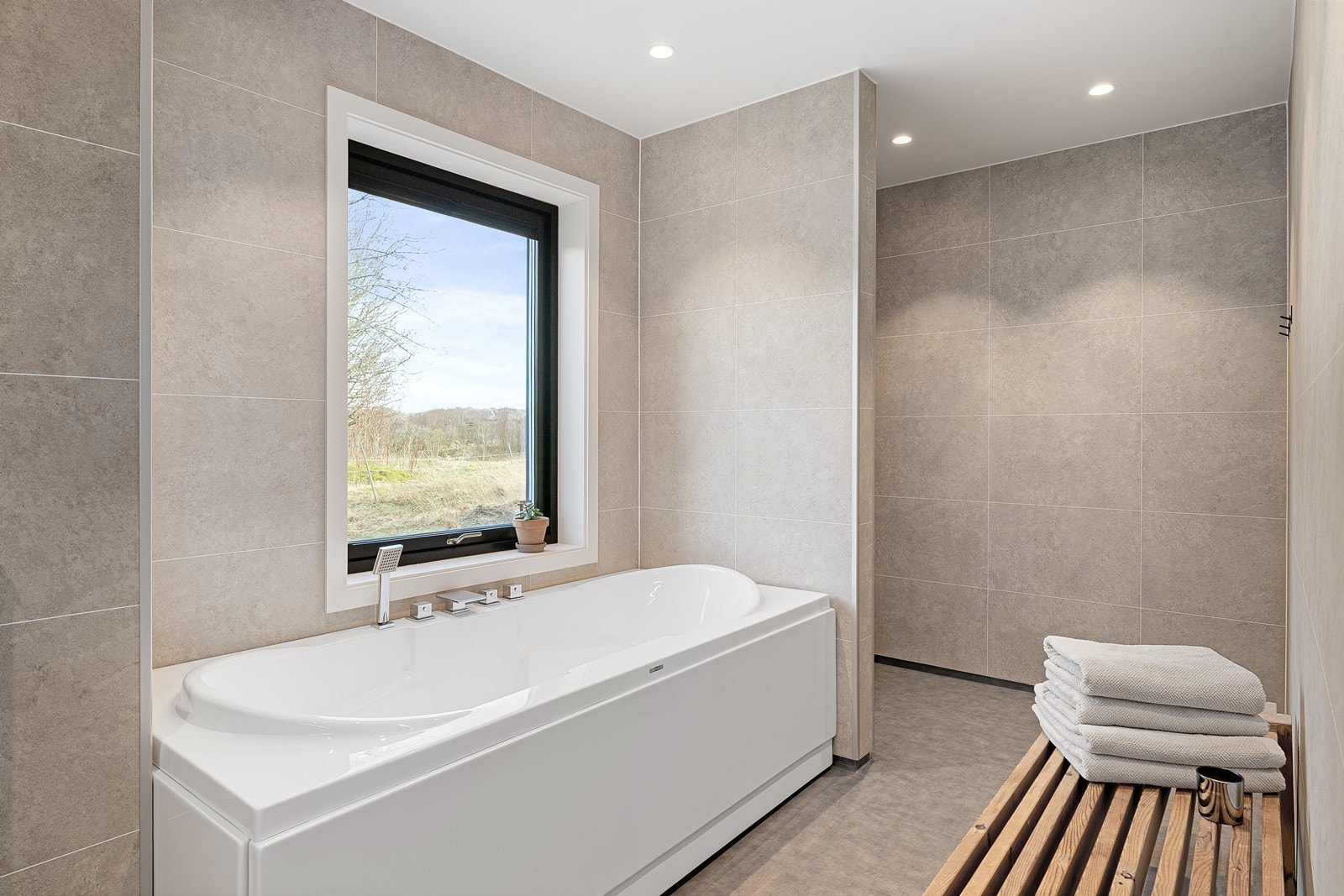 Lyst og trivelig bad med flere vinduer og god belysning i tak med spotter. Galleribilde