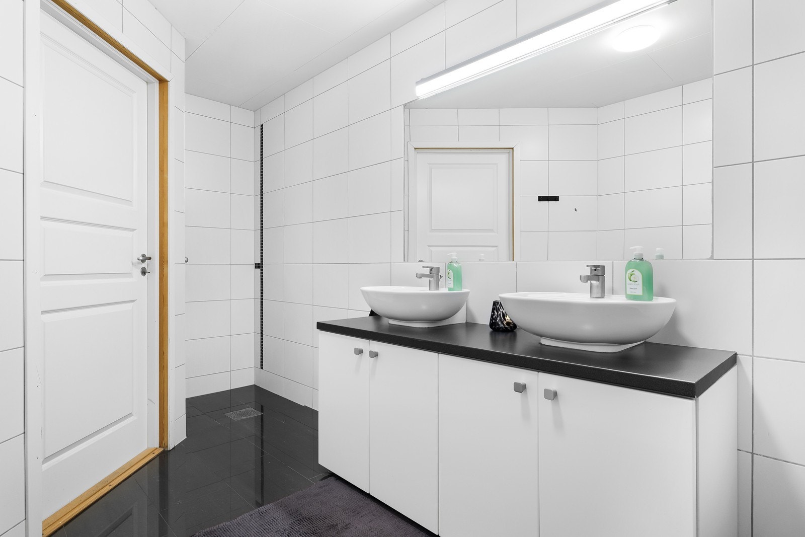 Rommet er helfliset med lyse vegger og mørke kontrastfliser på gulv. Galleribilde