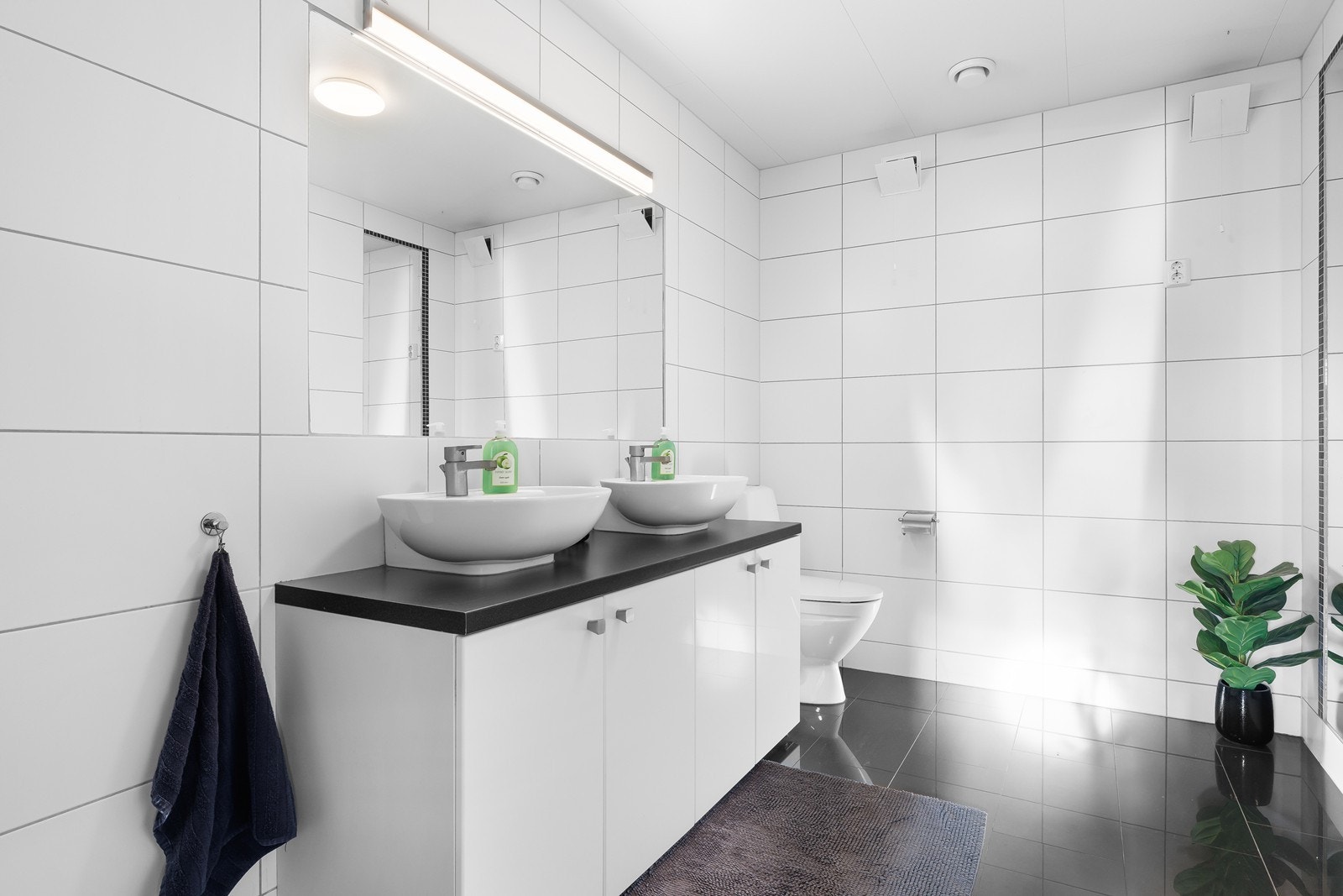 Moderne baderom med dobbel servant, skap under med god oppbevaringsplass og tilhørende speil over. Galleribilde