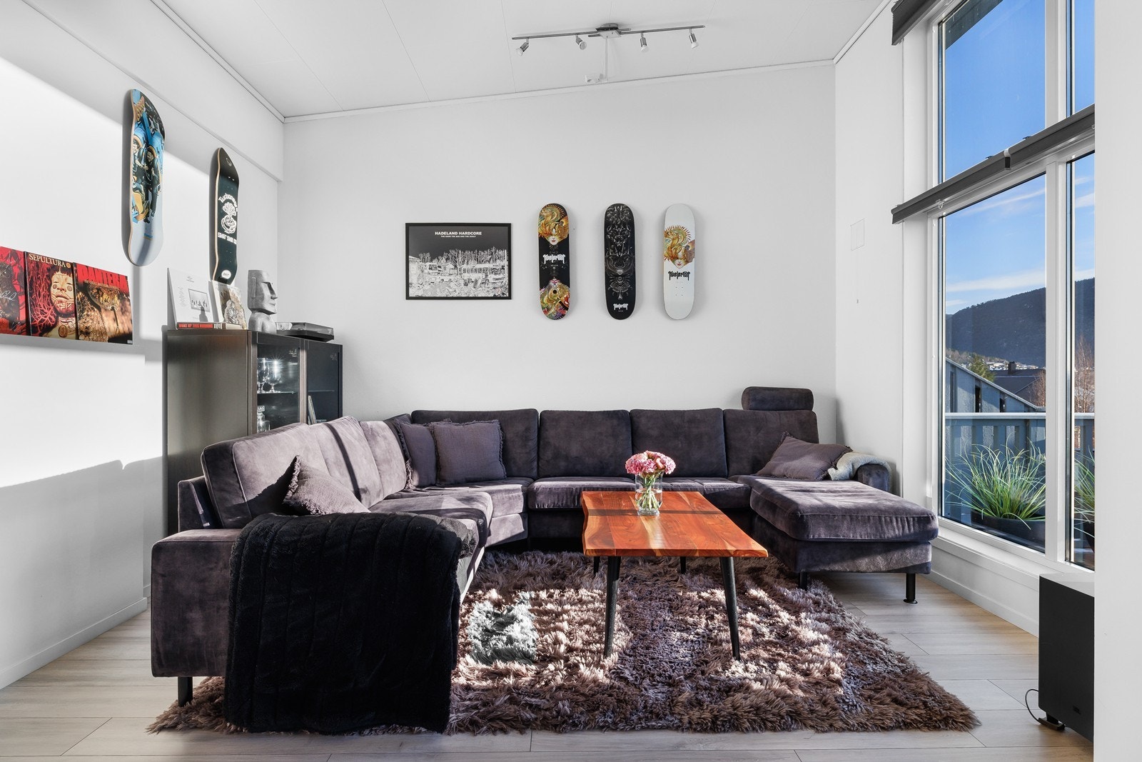 Stor og lys stue med store vindusflater og god takhøyde. Utgang til romslig terrasse. Moderne uttrykk og stilrene fargevalg. Laminat på gulv. Galleribilde