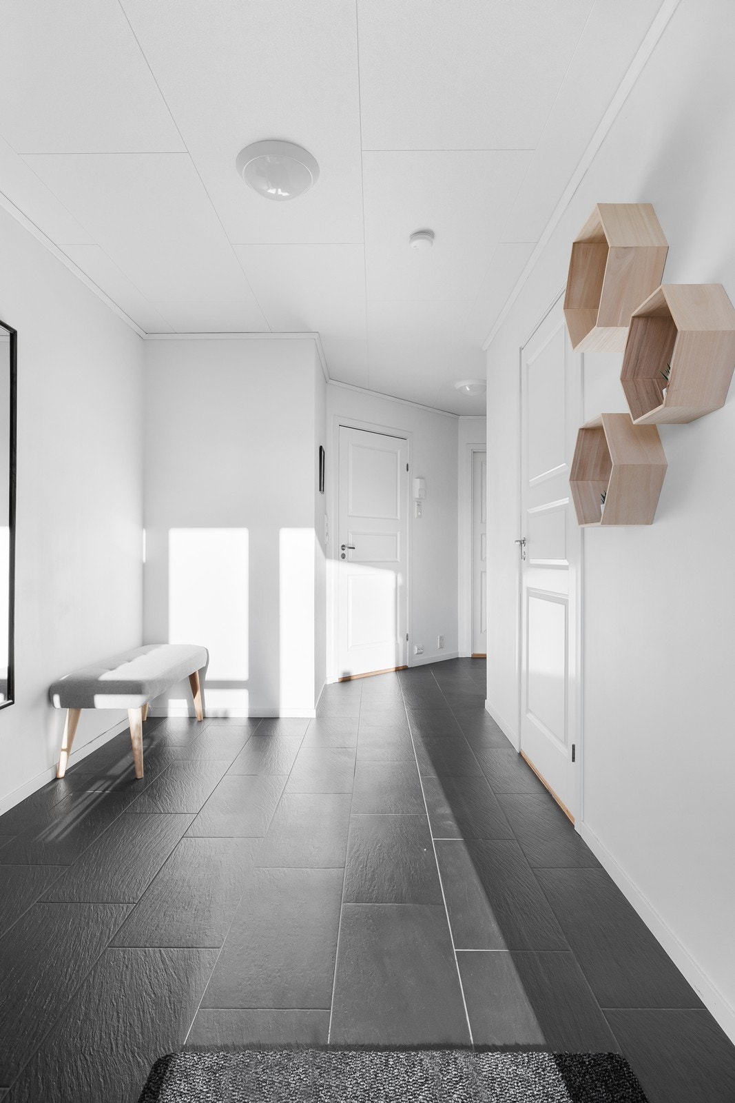 Praktiske mørke fliser på gulv og lyse vegger gir en tidsriktig følelse. Galleribilde