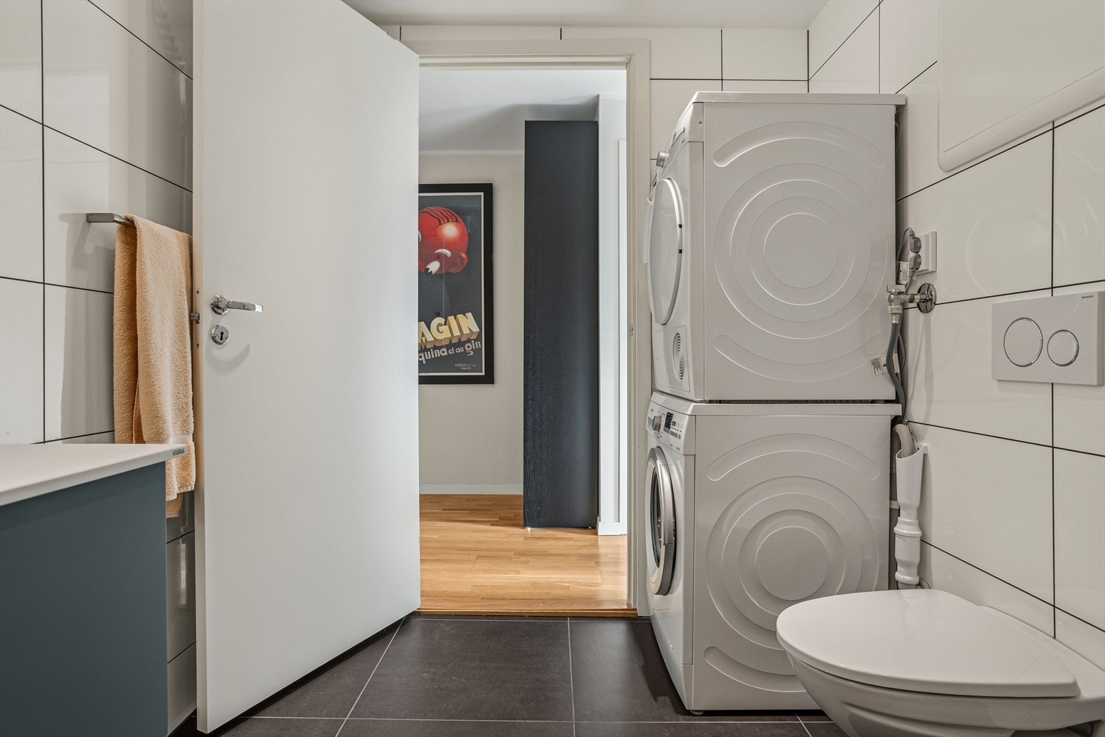 Baderommet har vegghengt wc, servant med skap, dusjhjørne med innfellbare dører og opplegg gtil vaskemaskin og tørketrommel. Galleribilde