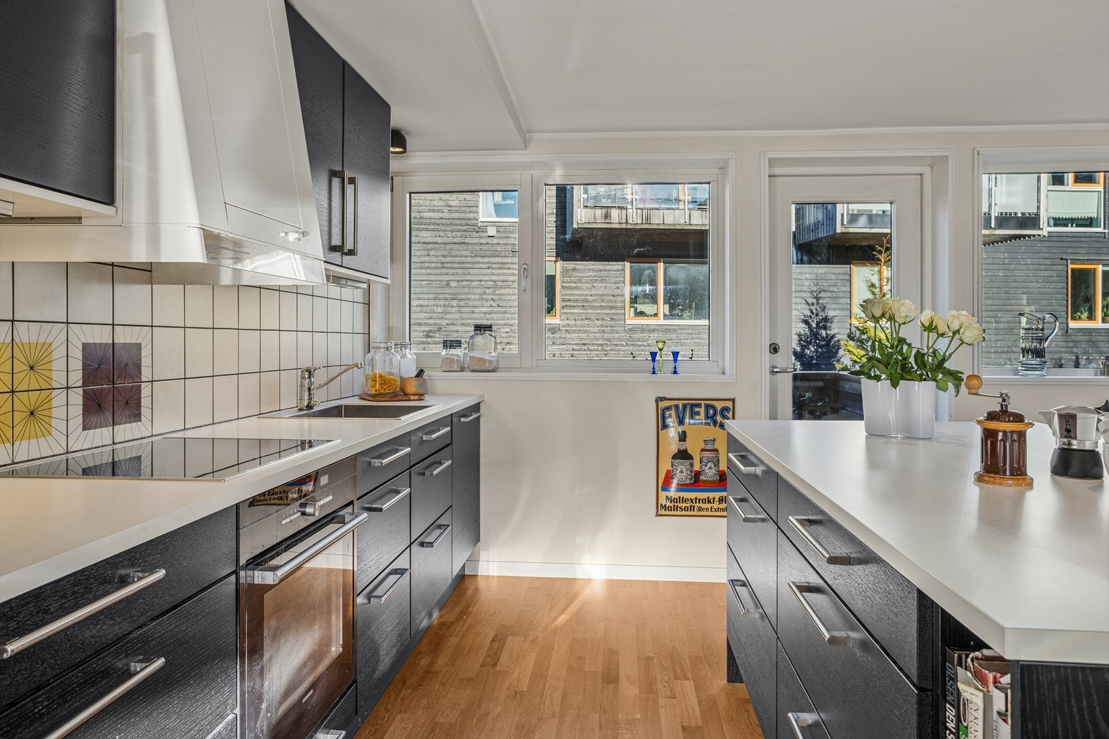 Kjøkkenet har moderne innredning fra Norema med glatte fronter og laminert benkeplate med fliser mellom over- og underskap. Galleribilde