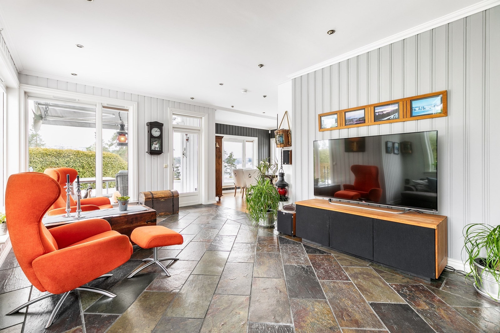 Mange vinduer med store flater fyller stuen med naturlig lys og skaper en luftig romfølelse. Galleribilde