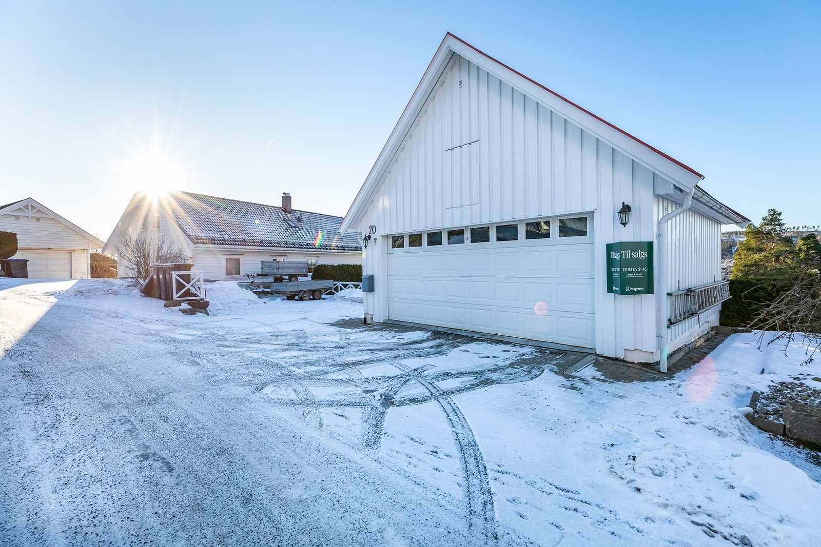 Lader til EL-bil er montert i garasjen. Porten er utstyrt med automatikk. Innkjørselen og arealene omkring garasjen er utført med belegningsstein. Galleribilde