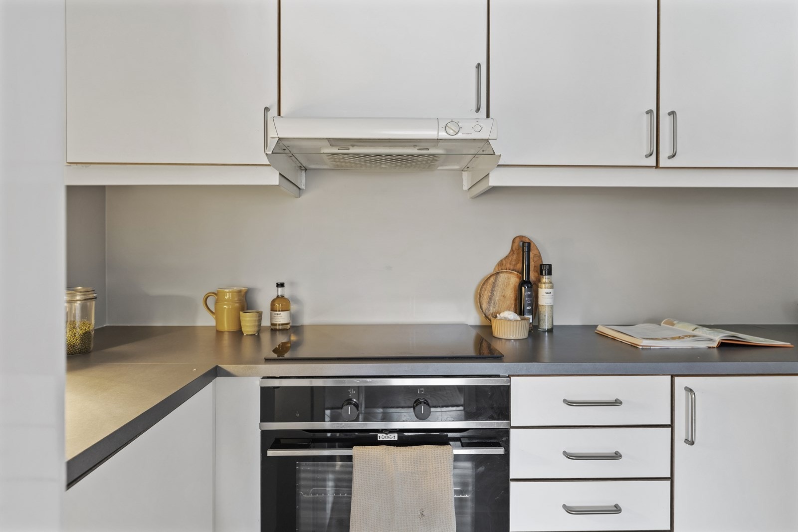 Laminat benkeplate med oppvaskkum og ett greps svingbart blandebatteri. Induksjon koketopp og innebygget stekeovn. Frittstående kjøleskap/fryser. Nisje til oppvaskmaskin Galleribilde