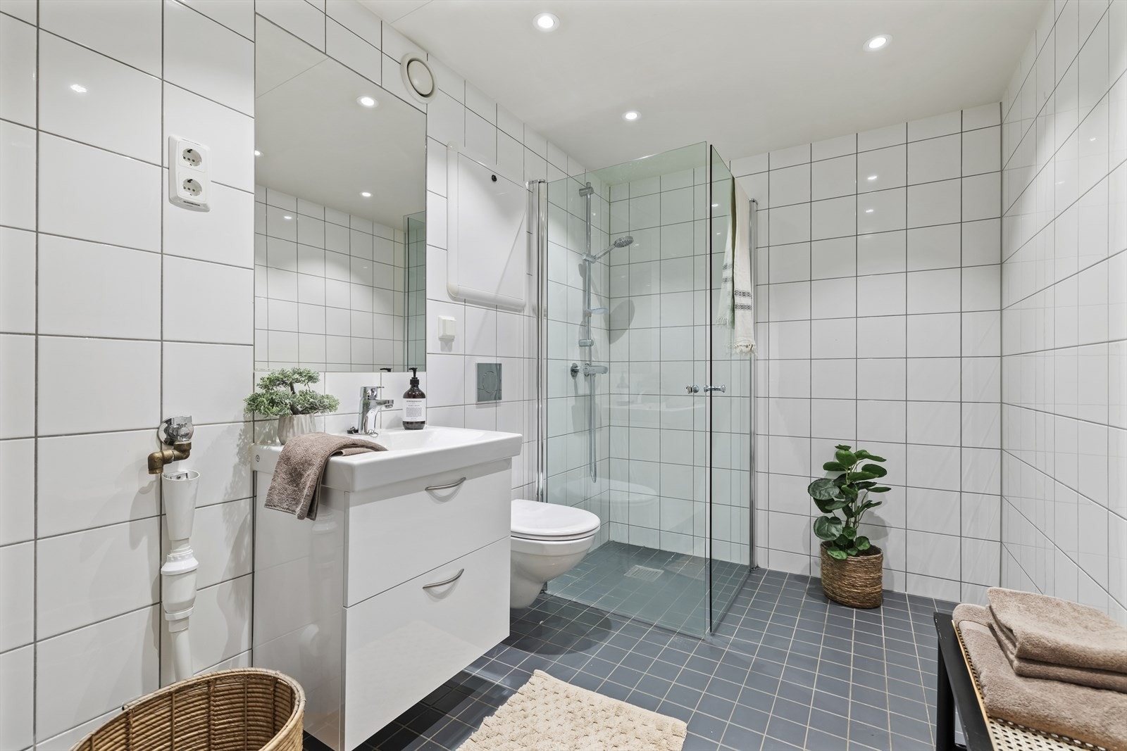 Pent flislagt baderom med ny baderomsinnredning og downlights Galleribilde