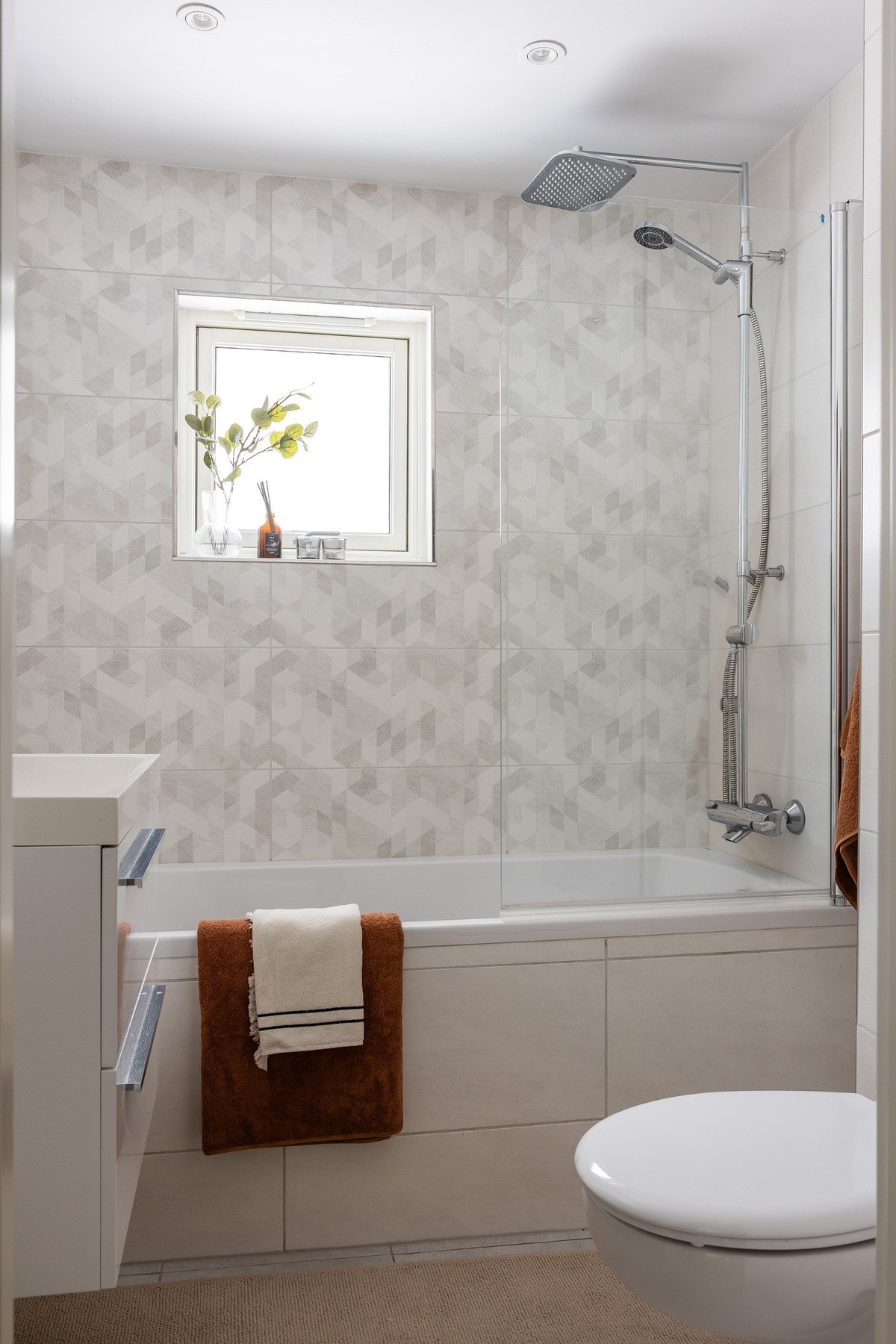 Det er flislagte overflater, gulvvarme, vegghengt toalett, servant med underskap samt innebygget badekar med dusjløsning. Galleribilde