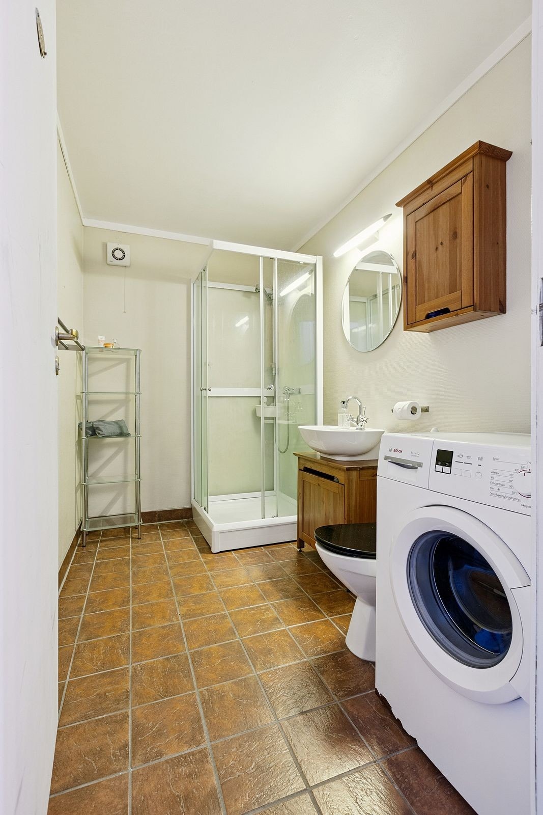 Badet er innredet med dusjkabinett og vaskemaskin. Galleribilde