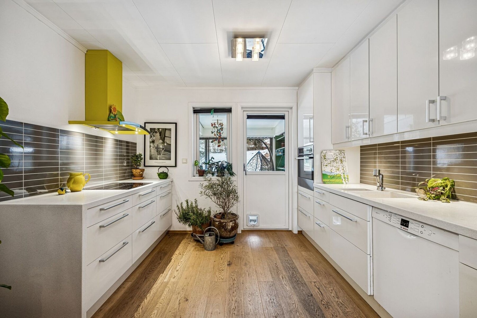 Kjøkkenet fremstår som lyst, moderne og elegant med høyglans innredning og kompositt benkeplate Galleribilde