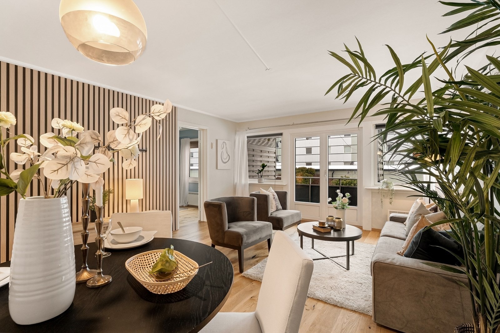 Romslig stue- og spiseområde med dobbeltfløyet balkongdør som gir rikelig lysinnslipp og en naturlig forbindelse til uteplassen. Galleribilde