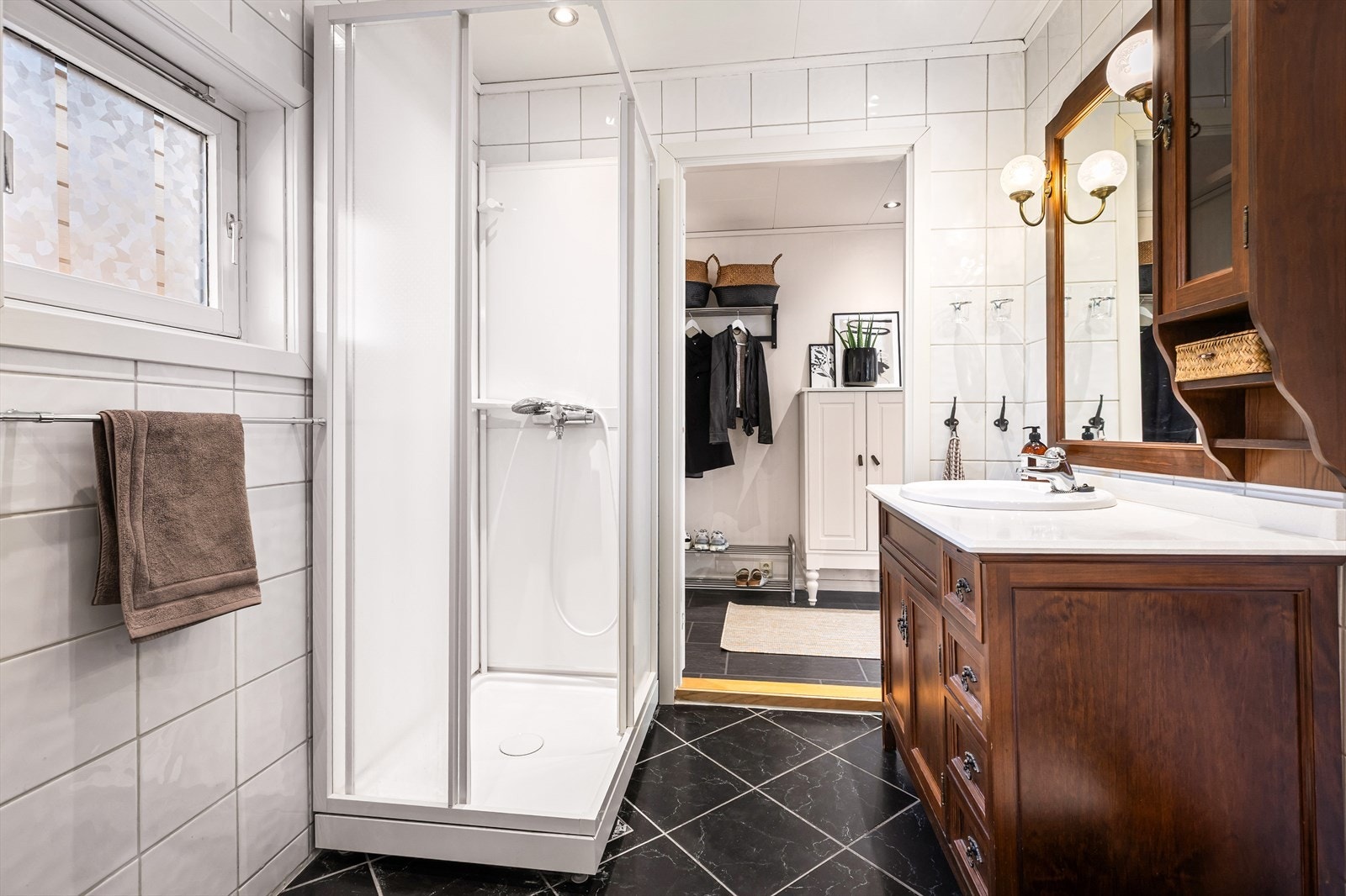 Badet er innredet med servant, toalett, vaskemaskin og dusjkabinett. Galleribilde