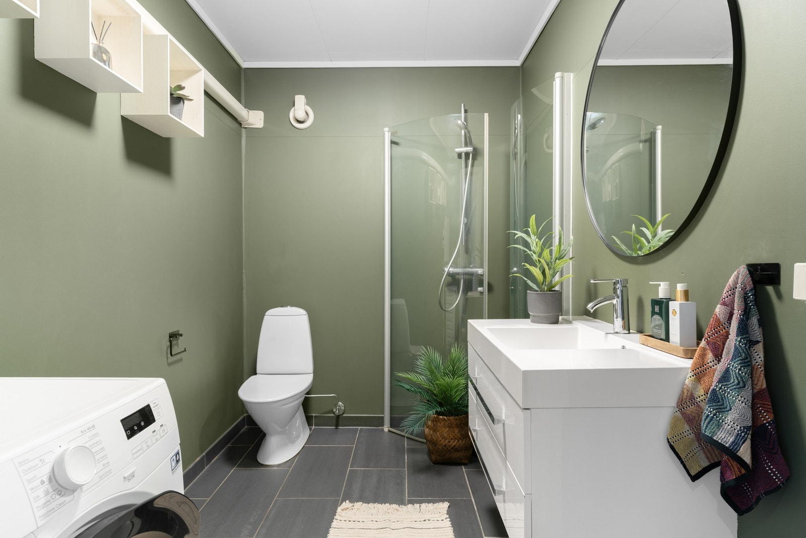 Badet i 1. etasje fremstår som funksjonelt og innbydende, med fliser på gulv og malt vinylbelegg på veggene. Galleribilde