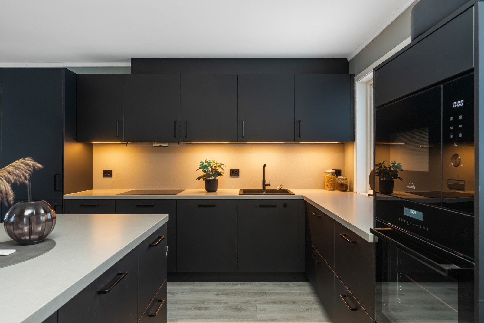 Kjøkkenet har mange flotte sorte detaljer som vask, armatur, hvitevarer og stikkontakter. Galleribilde
