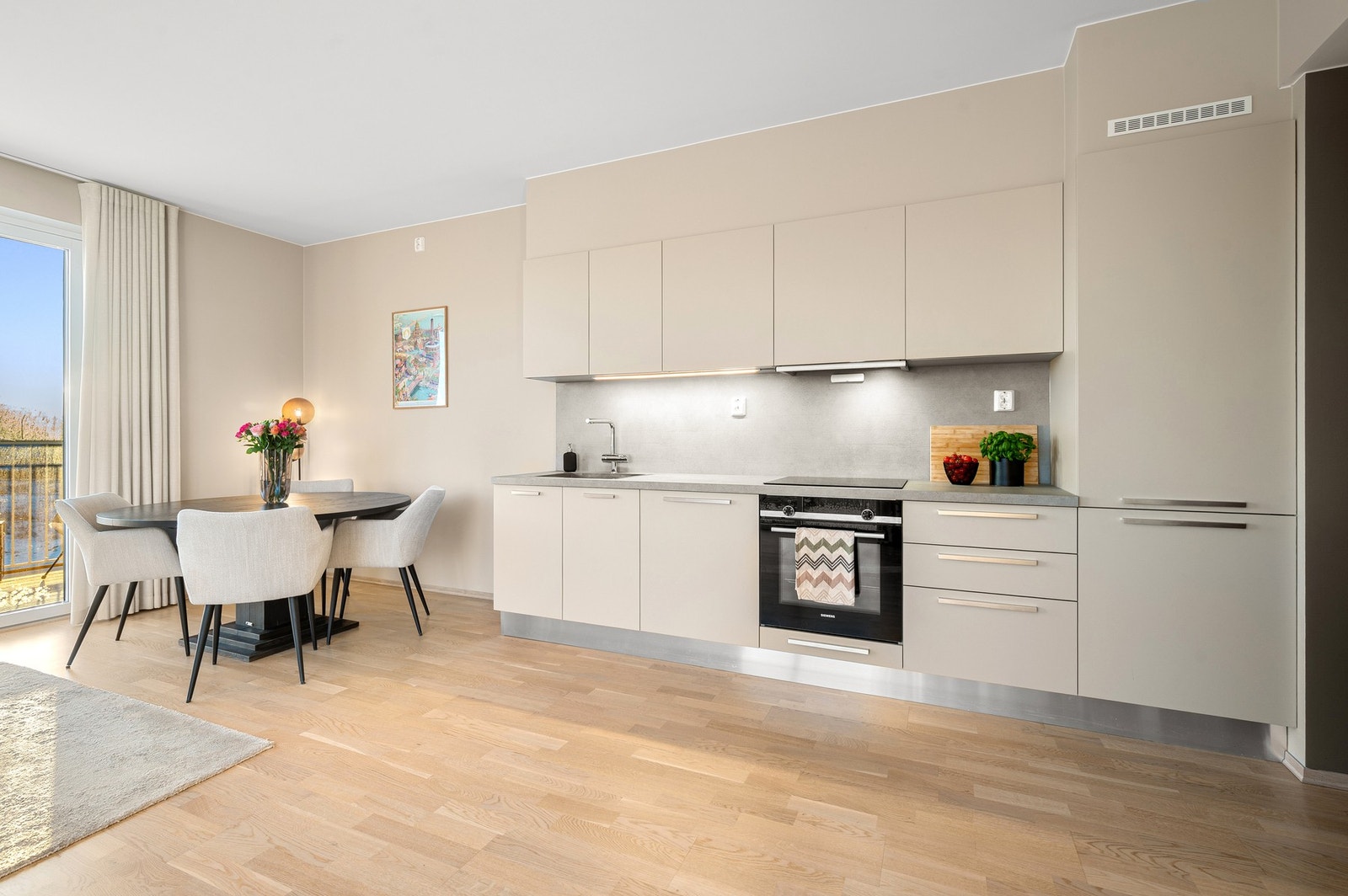 Lyst og pent kjøkken fra 2023 med stilren innredning og integrerte hvitevarer. Galleribilde