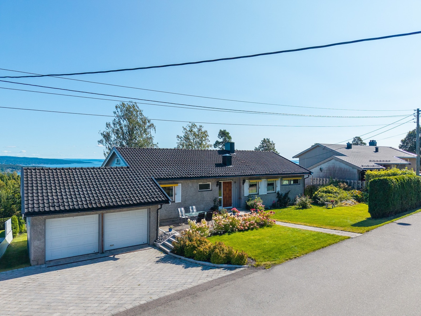 Meget pent inngangsparti steinlagt gårdsplass og fin beplantning Galleribilde