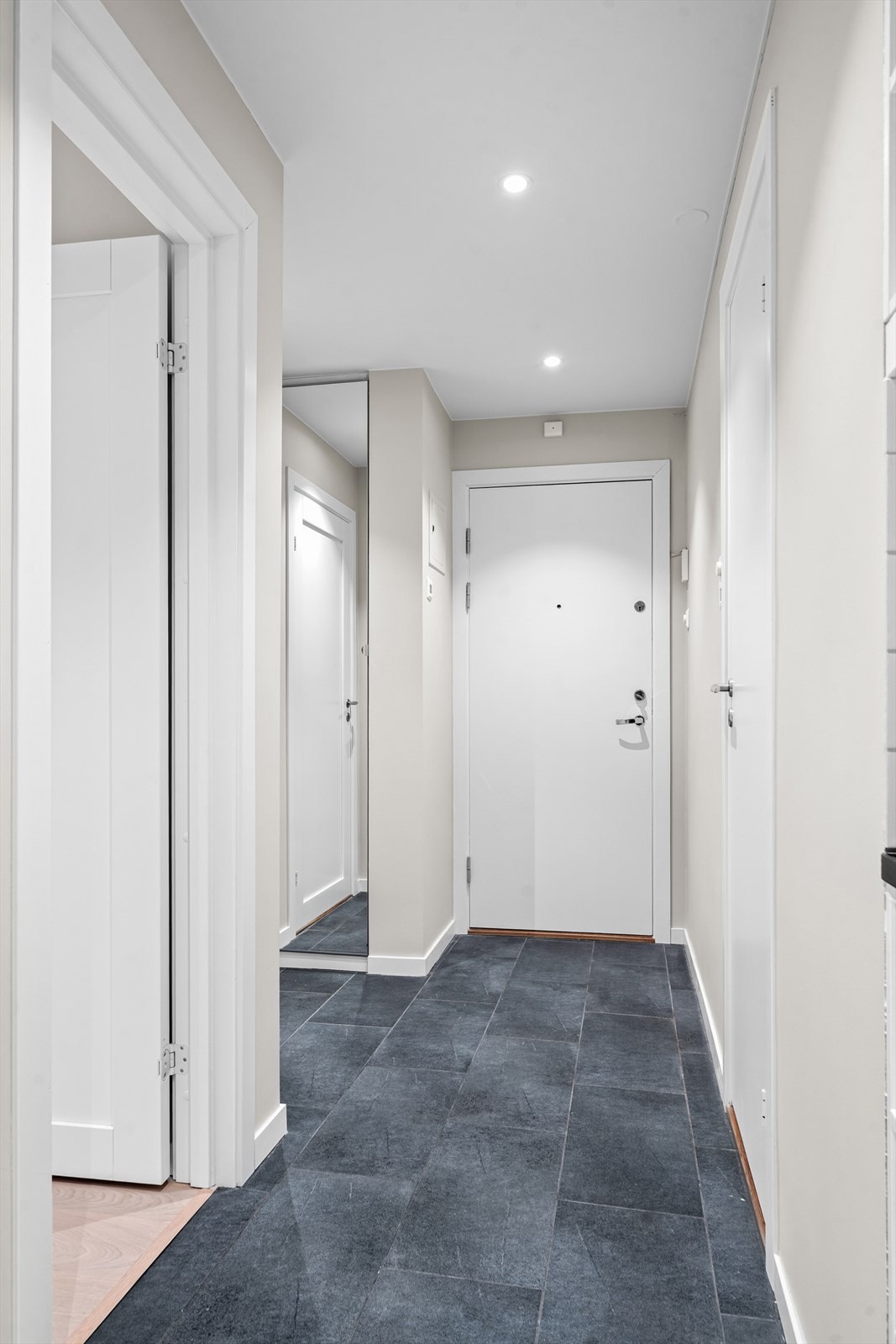 Flislagt entré/gang med varmekabler og plassbygget garderobeskap med speilfronter. Brann- og lydklassifisert entrédør med kikkhull. Galleribilde