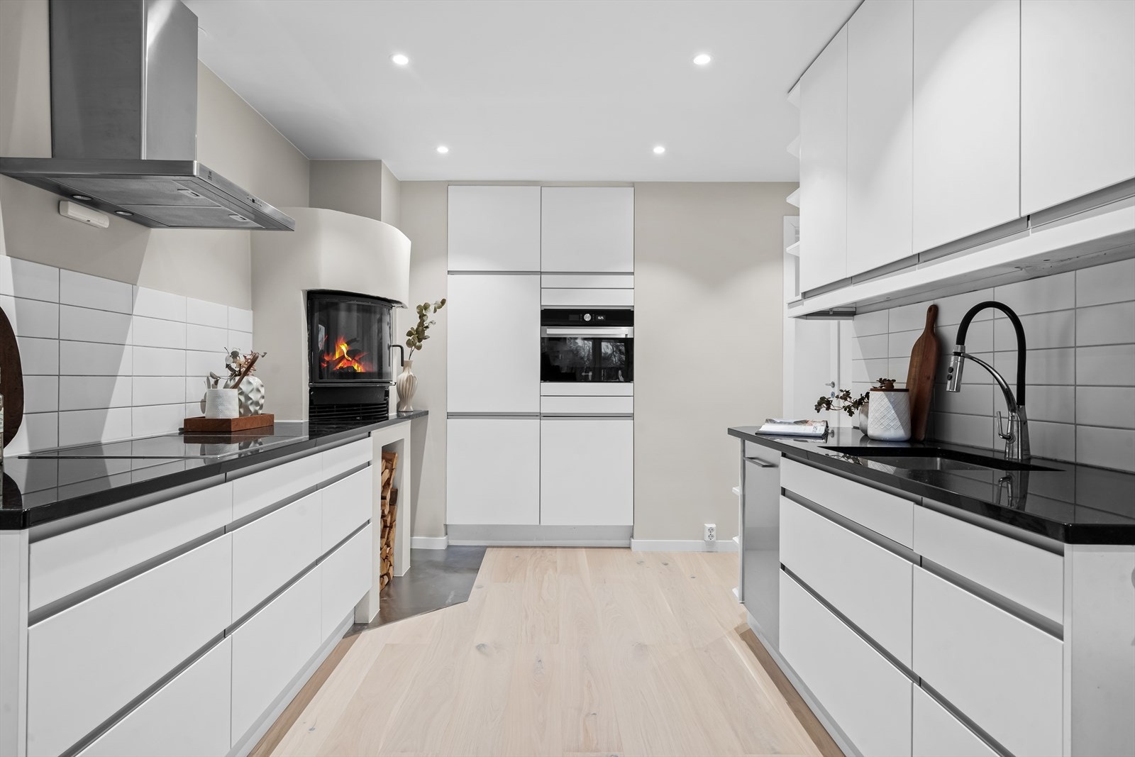 Svært god skap- og benkeplass. Integrerte hvitevarer inkluderer induksjonstopp, oppvaskmaskin, kombi kjøle- og fryseskap samt stekeovn (ny 2026). Galleribilde