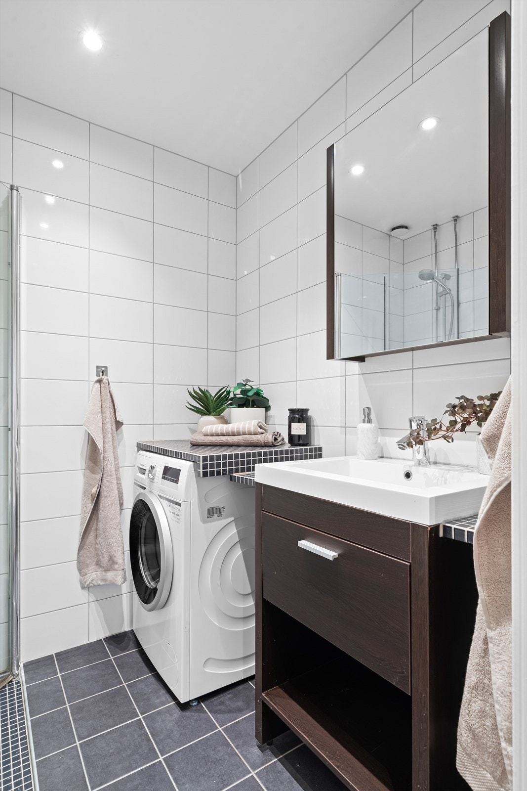 Plassbygget benk og baderomsinnredning med skuffer, speilskap og opplegg for vaskemaskin under benk. Galleribilde