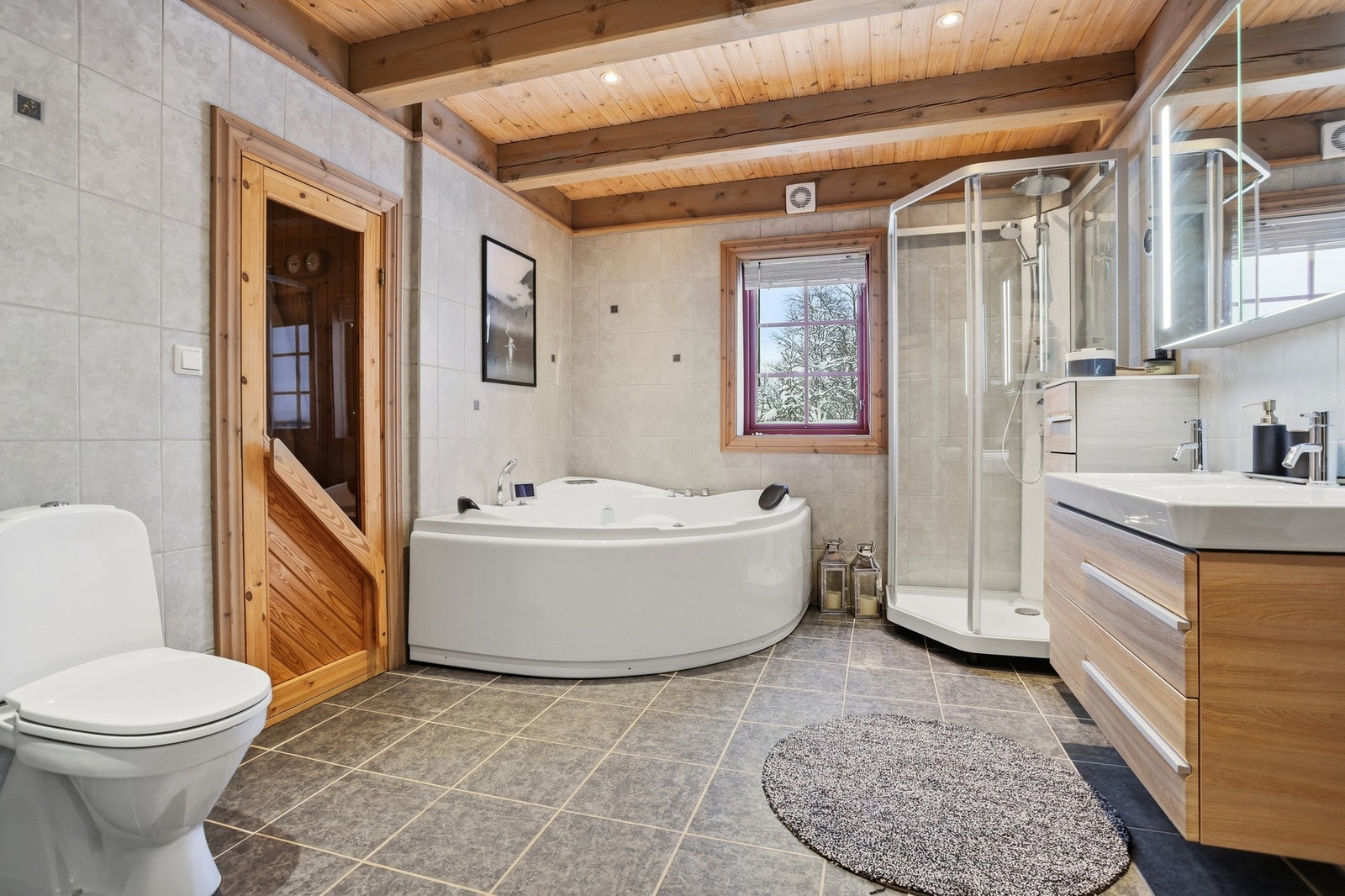 Lyst og delikat bad med spa-følelse. Badet inneholder innredning med servant og speilskap, badekar og dusj. Varmekabler i gulv og downlights i himling Galleribilde