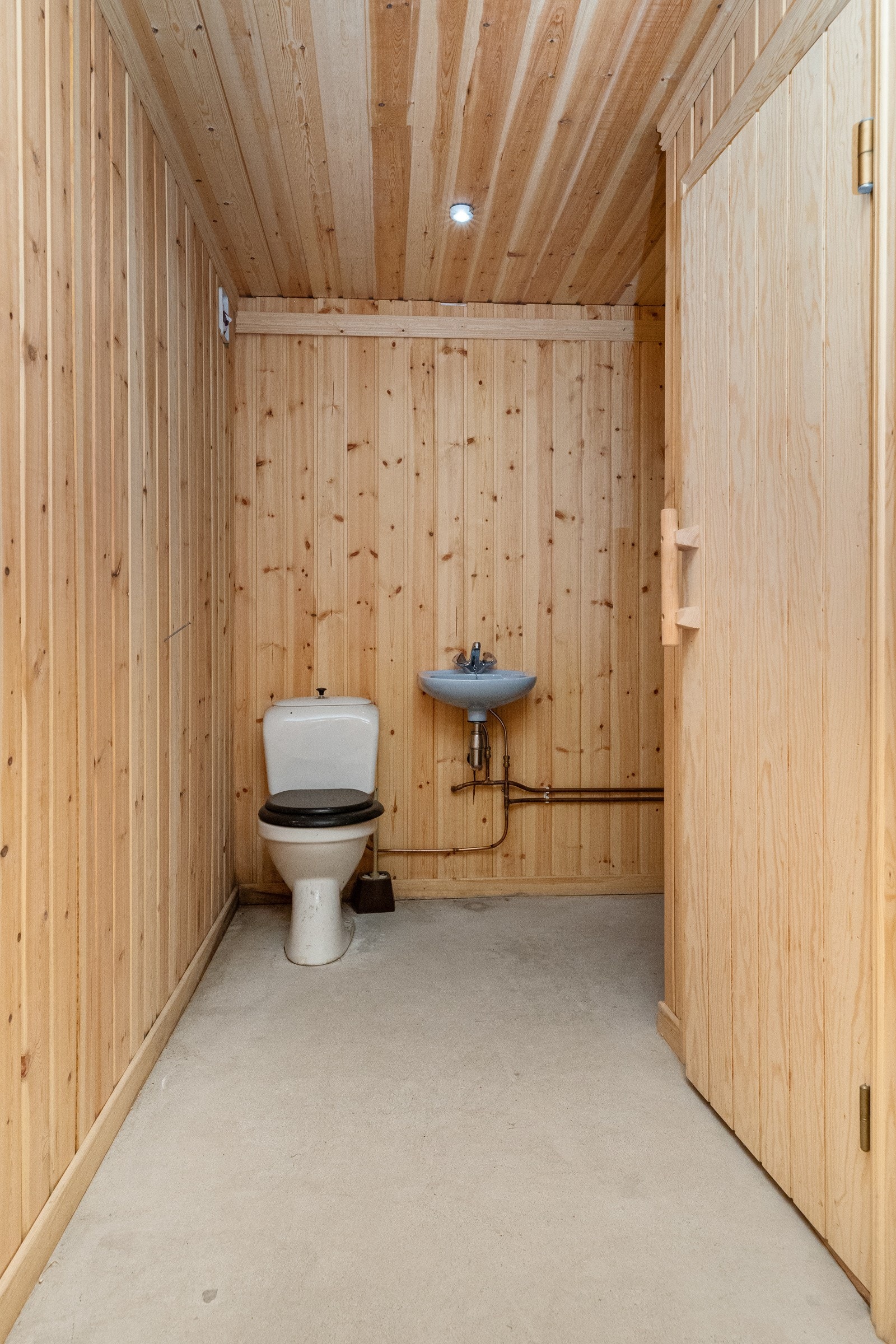 Badet i kjeller har servant, dusjhjørne og toalett Galleribilde