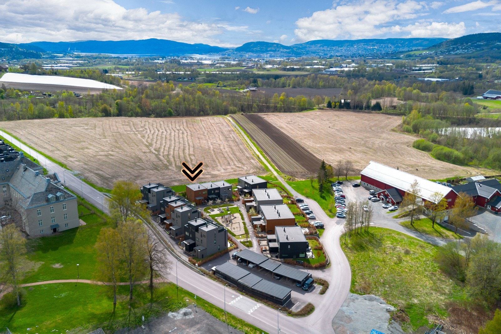 Moderne boligområde med rekkehus, omgitt av åkre og landlig utsikt. Kort avstand til by og fjord. Galleribilde