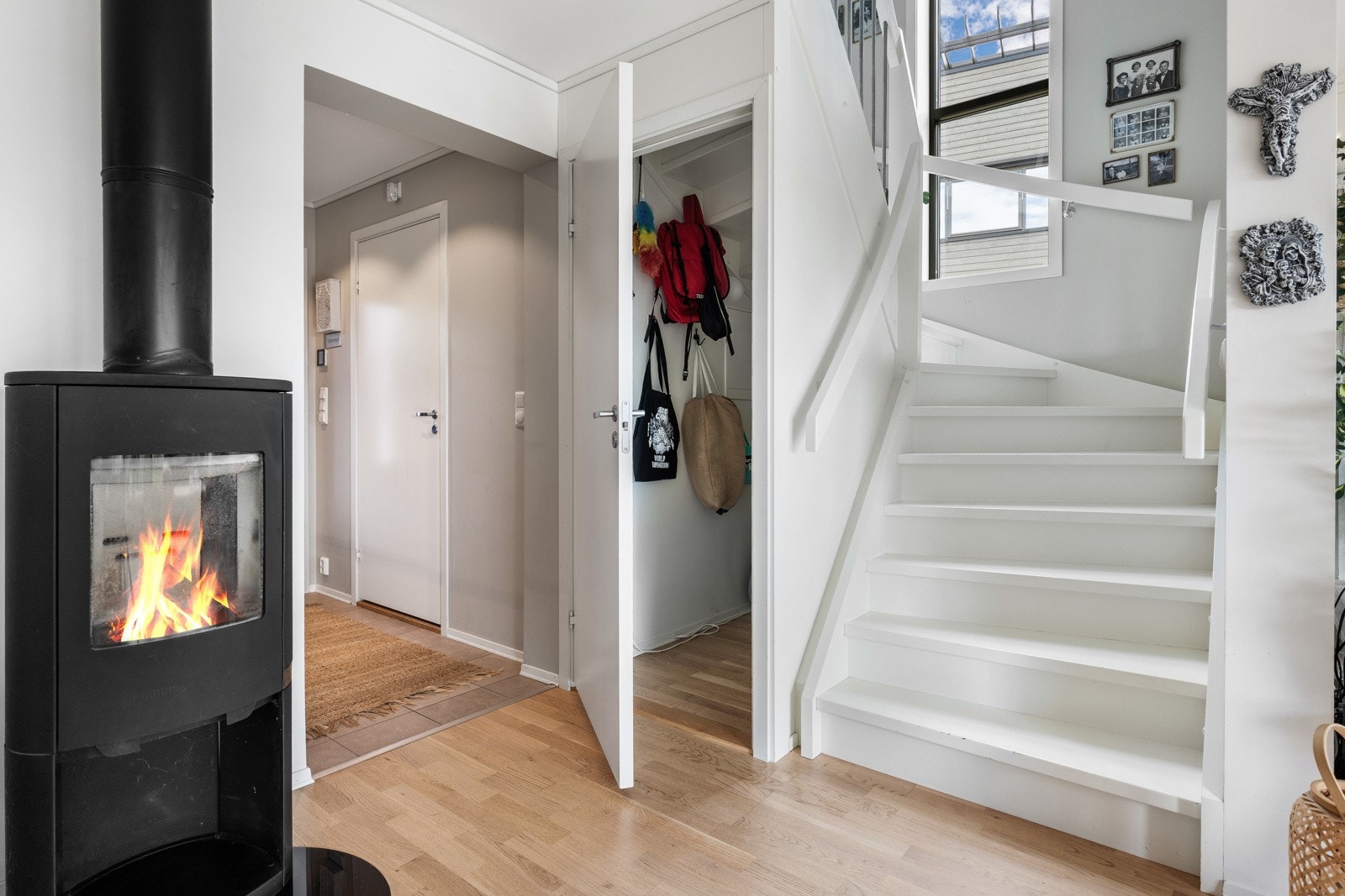 Lys og moderne gang med peis, trapp til andre etasje og inngang til bod. Galleribilde
