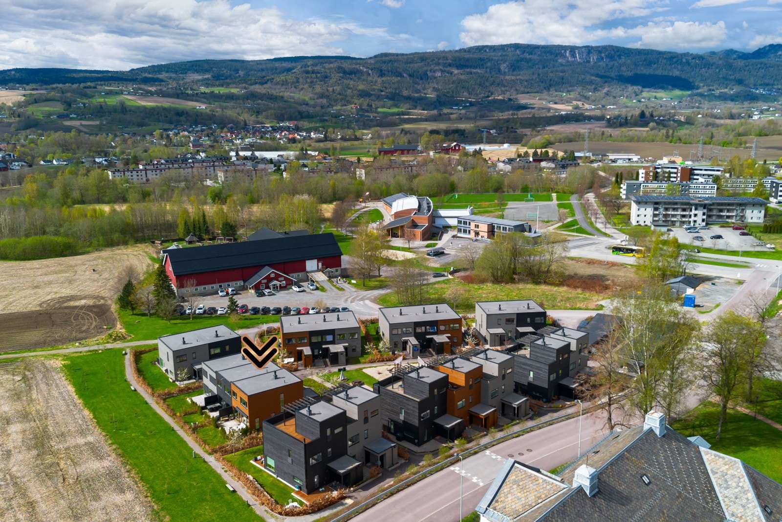 Moderne boligområde med rekkehus, omgitt av grønne områder og nærhet til skoler og idrettsanlegg. Galleribilde