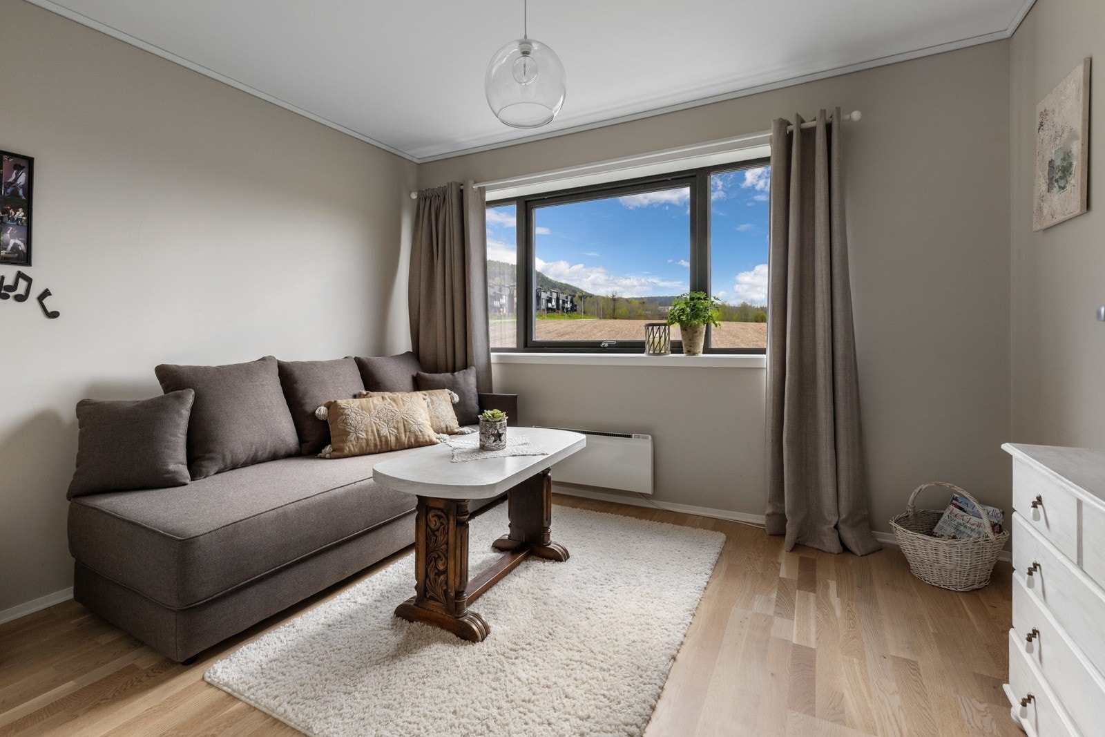 Lyst rom med stort vindu som gir fin utsikt. Vegger og møbler i jordnære farger. Galleribilde