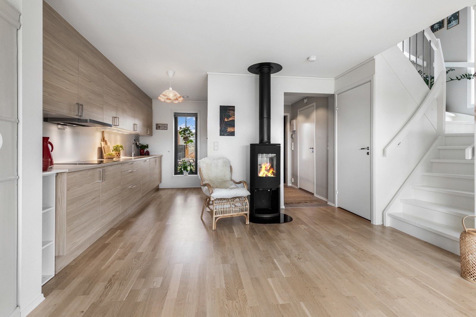 Lyst rom med åpen kjøkkenløsning, peisovn og trapp til andre etasje. Store vinduer gir godt med naturlig lys. Galleribilde