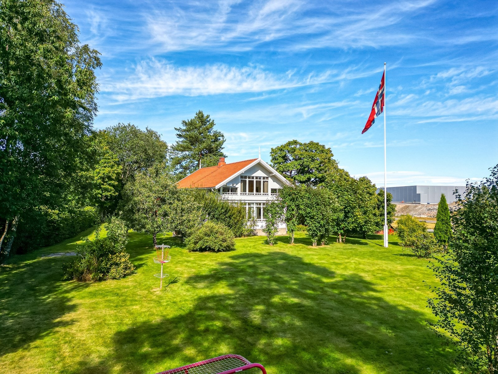Den store, grønne hagen gir et nydelig førsteinntrykk og setter rammen for en eiendom der uteområdet virkelig kan nytes Galleribilde